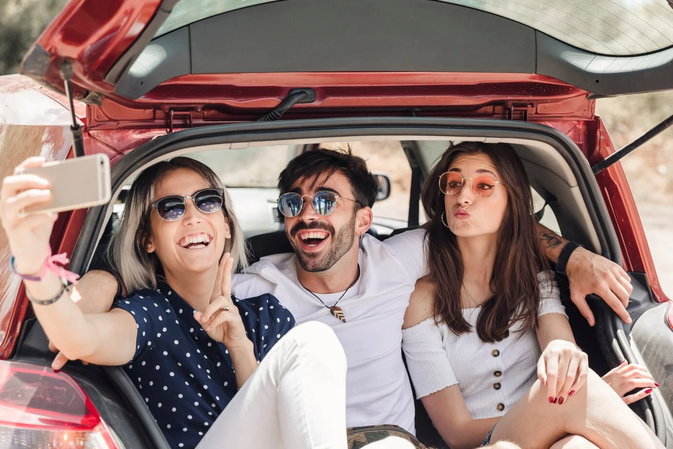 Amigos en la parte trasera del auto tomándose una foto
